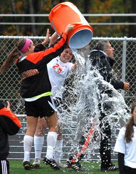Senior Captains Emma Kate Womack and Rae Reed douse head coach Vince Pimpinella after beating Kiski and clinching the playoffs for the first time in 21 years.