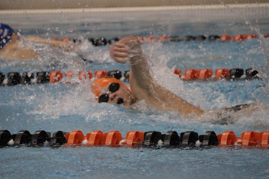 Freshman Colin Spehar takes a quick breath of air during his freestyle at the first swim meet of the season.