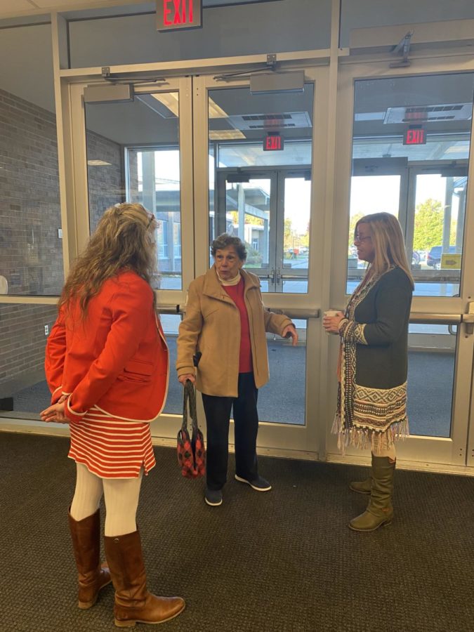 Mrs. Nakles is captured telling the story of her previous neighbor, Ms. Hager to Mrs. Stallings in the entryway of the high school.