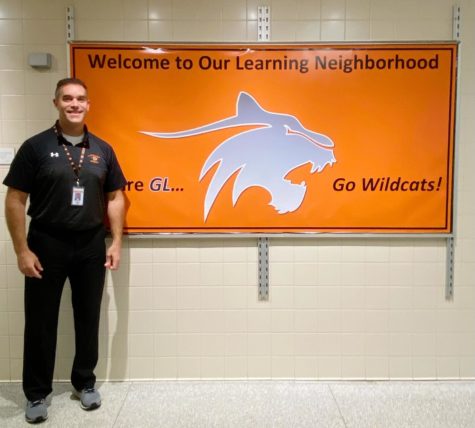 Dr. Benning is pictured standing proudly by his favorite bulletin board in the senior high school.