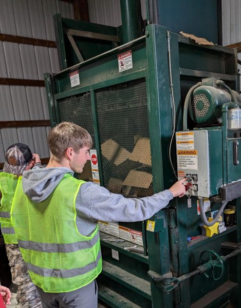 Max Butler starting the recycled cardboard baling machine.