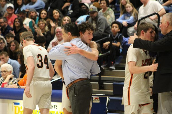 Senior Kyle McNeil hugs Coach Wetzel while Max Butler hugs his father Eric Butler late in the fourth quarter. 